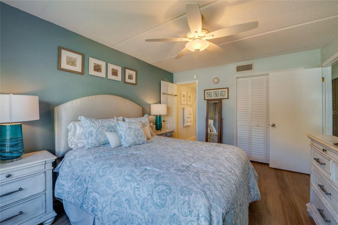 Photo 16 of 20: Another view of the primary bedroom showing generous space, neutral finishes, and convenient access to the en-suite bathroom.