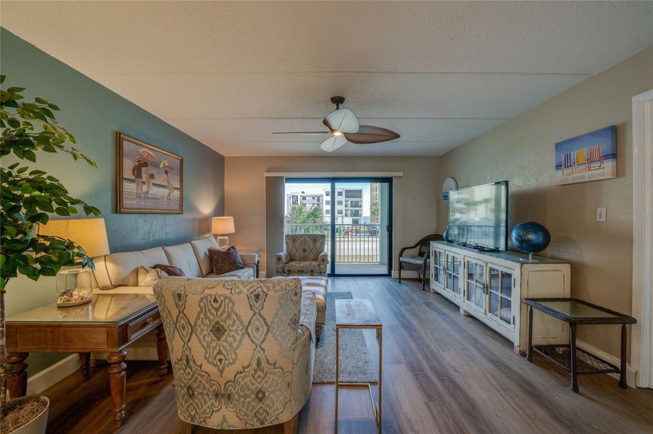 Photo 12 of 20: Additional view of the living room highlighting the spacious layout and easy connection to the dining area and balcony.