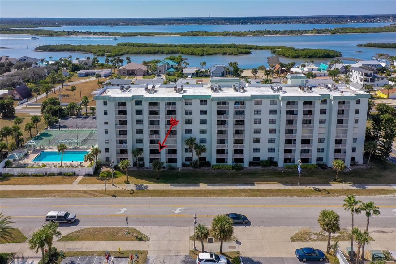 Photo 2 of 20: Straight-on aerial view of the building’s front elevation, clearly identifying the unit’s location within the structure and its proximity to community amenities.