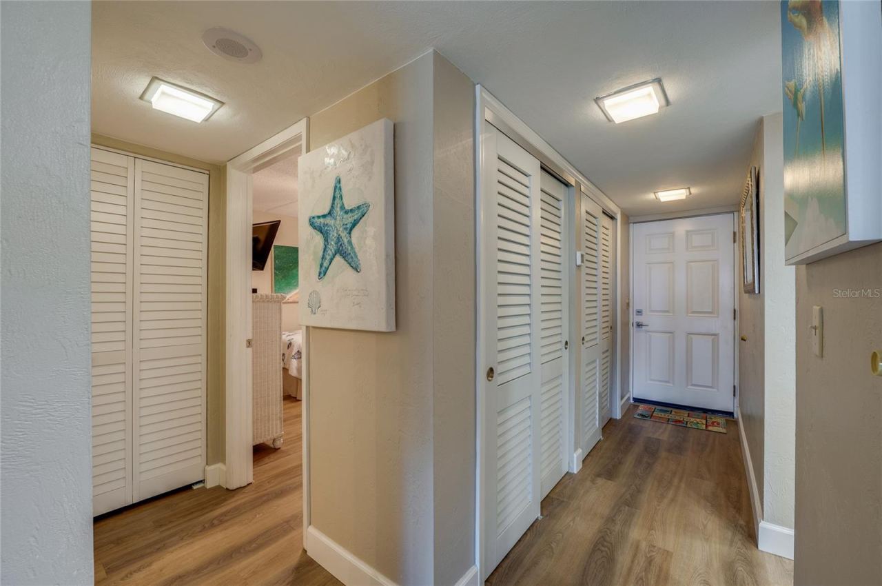 Photo 14 of 20: Inviting entry hallway with vinyl plank flooring and multiple storage closets, offering a clean and organized first impression.