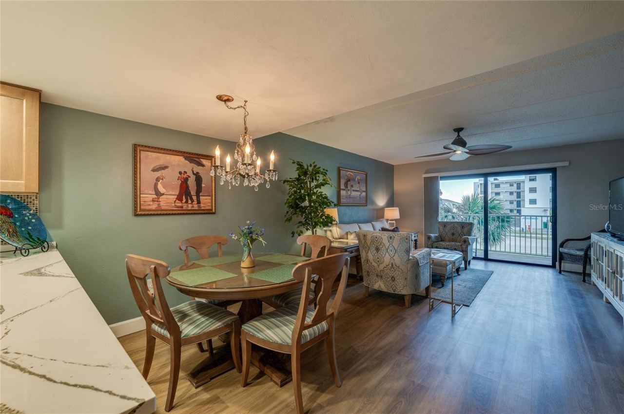 Photo 9 of 20: Defined dining area featuring a chandelier and vinyl plank flooring, comfortably positioned adjacent to the kitchen and living space.