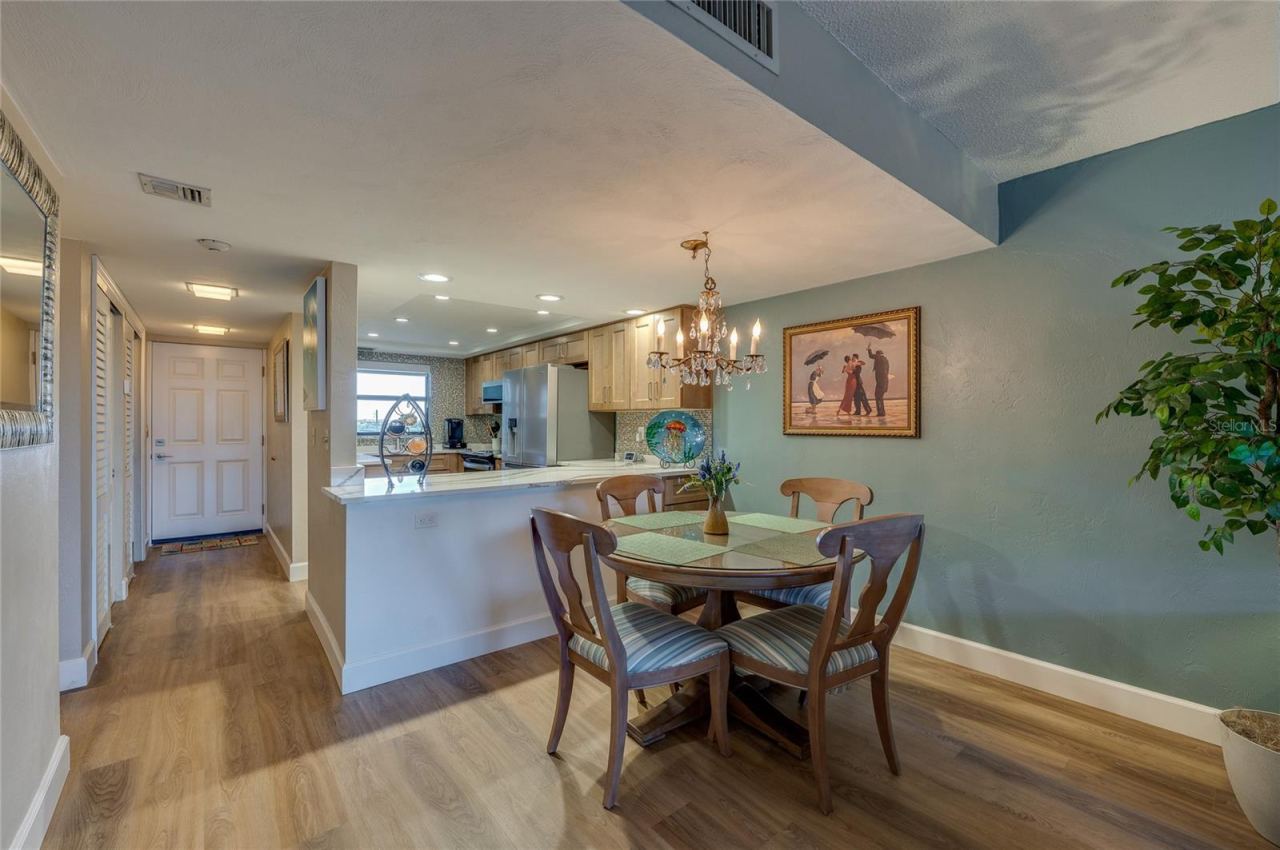 Photo 10 of 20: Dining area overlooking the kitchen with ample counter space, recessed lighting, and a seamless flow toward the entry hallway.