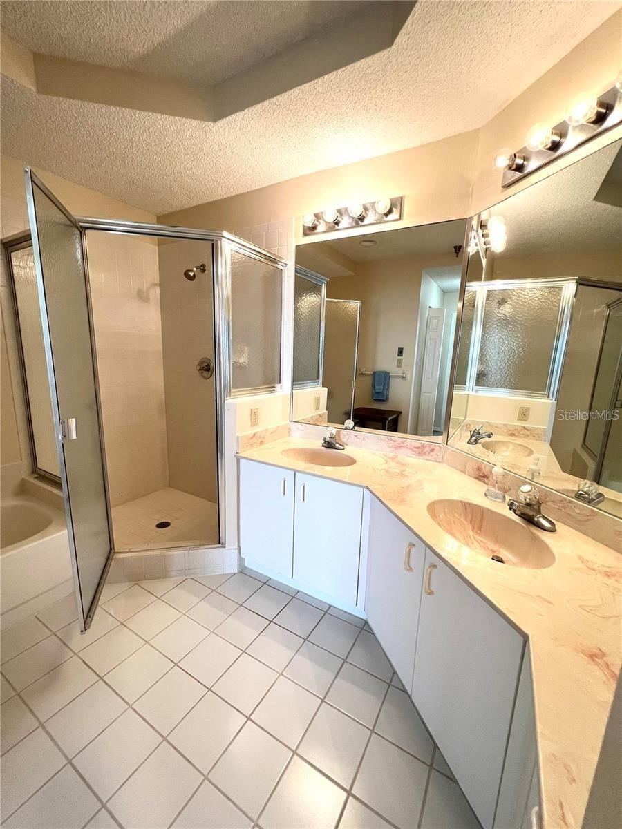 Photo 16 of 20: Ensuite primary bathroom. Tile walk on shower, separate tub, double sinks
