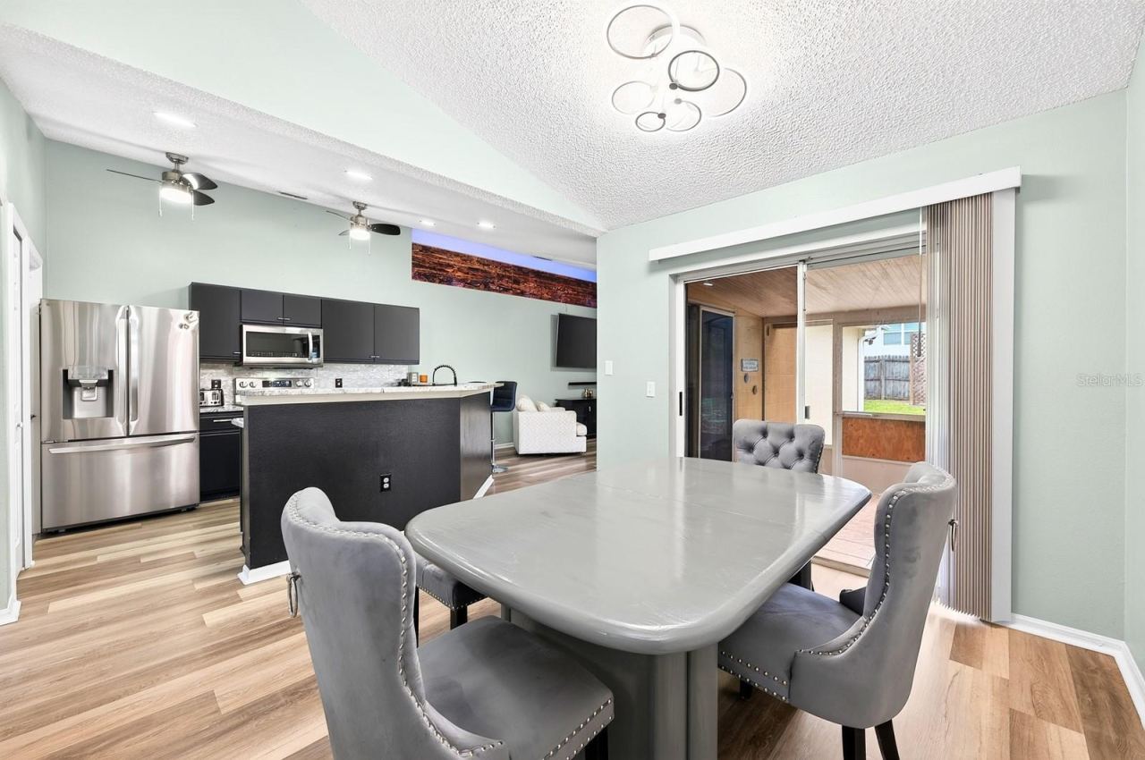 Photo 3 of 20: Dining room is open to the kitchen with its own set of sliding glass doors that open to the lanai.
