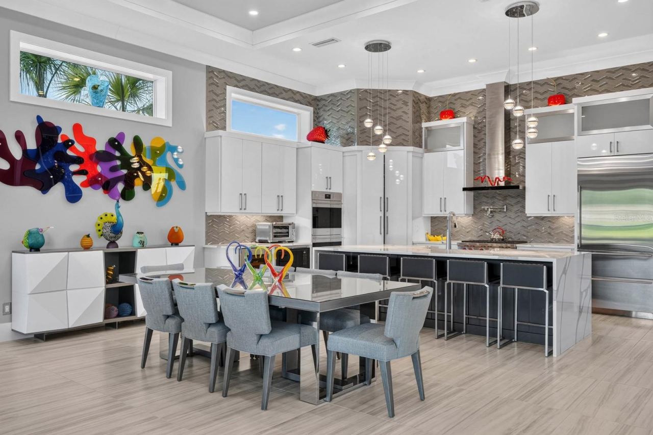 Photo 17 of 20: Designed to gather. An expansive open kitchen and dining area with soaring ceilings, designer lighting, custom cabinetry and professional-grade appliances creates a natural centerpiece for the main living level.