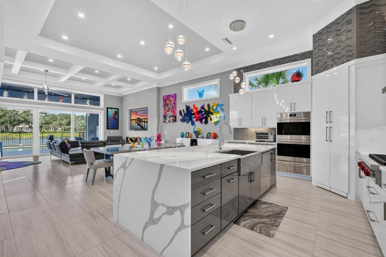 Photo 5 of 20: A kitchen built to be used and enjoyed. Statement quartz surfaces, custom cabinetry, premium appliances and designer lighting anchor the open-concept main living level, with the Intracoastal always in view.