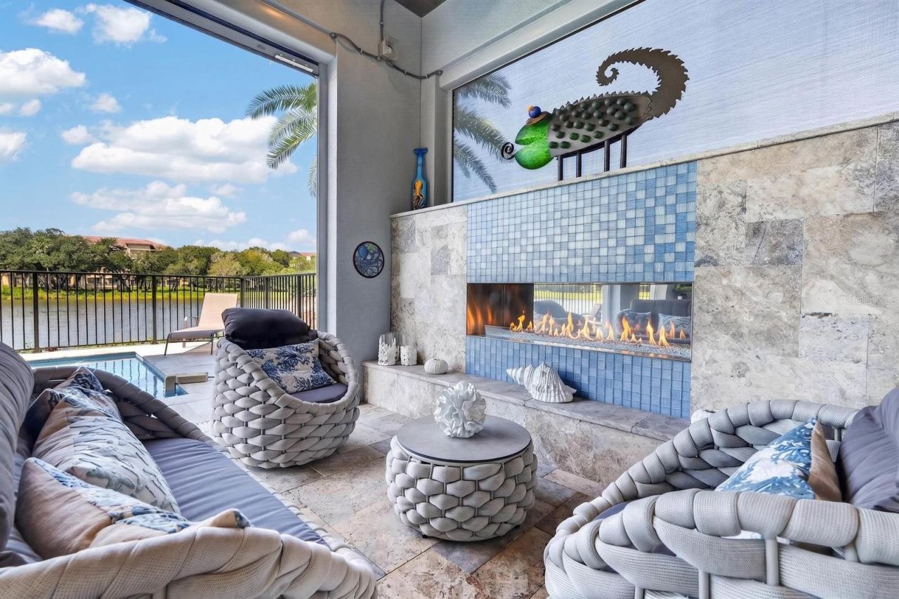Photo 3 of 20: Indoor-outdoor living was part of the design. Covered poolside living with an outdoor gas fireplace, custom hurricane-rated screens and uninterrupted views of the Intracoastal.
