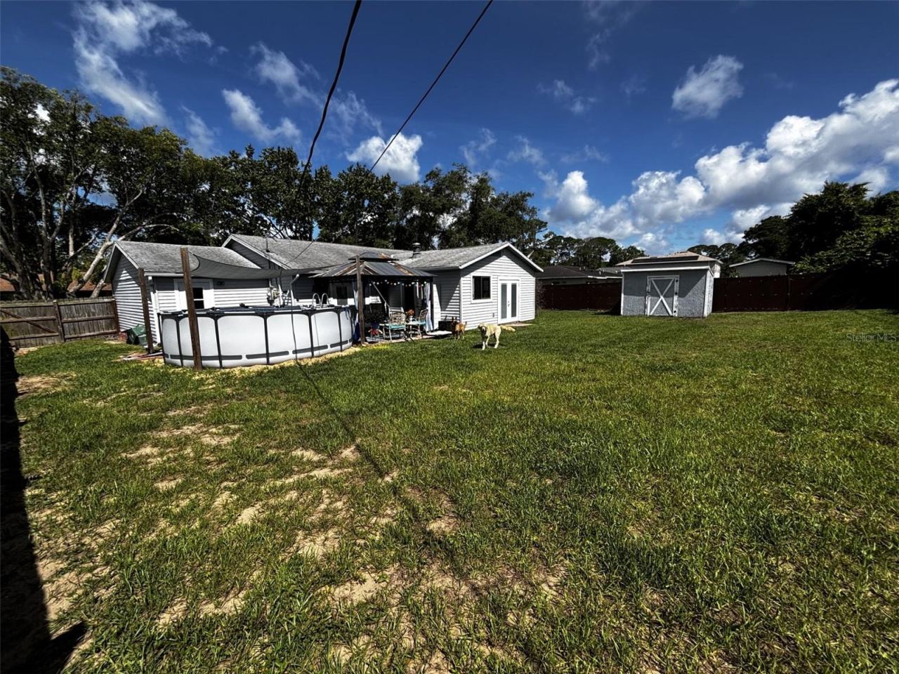 Photo 3 of 20: Large fenced yard w/shed & pool.