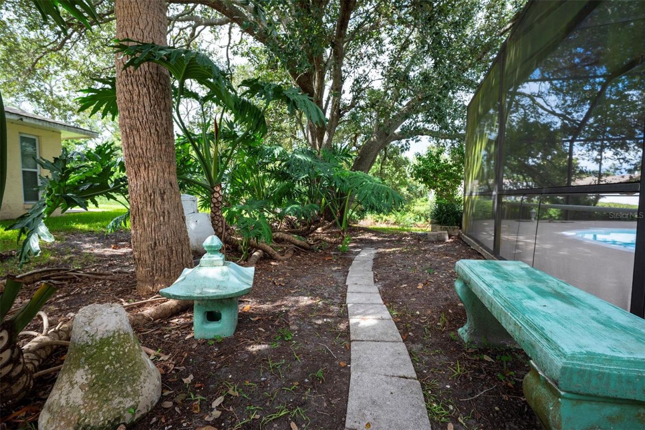 Photo 10 of 20: Small garden area with bench outside the lanai