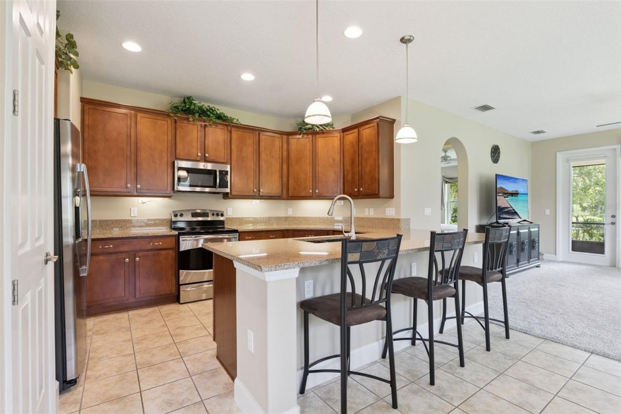 Photo 7 of 20: 11' x 12' Kitchen w/ 42" Maple wood cabinets, under cabinet lighting, electric glass top range & granite countertops