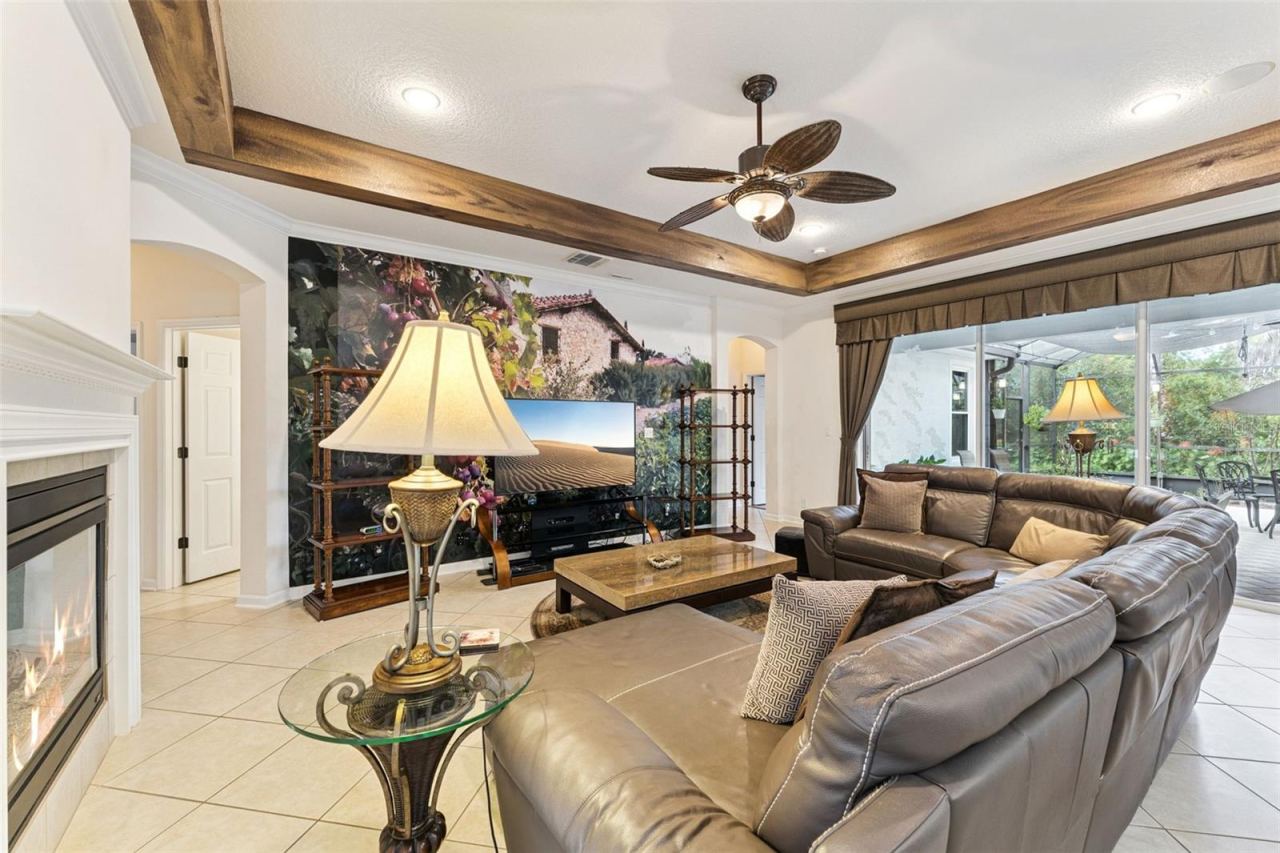 Photo 14 of 20: 17' x 21' Family Room w/ recessed lighting, tray ceiling w/ painted border, ceiling fan & electric floor outlet