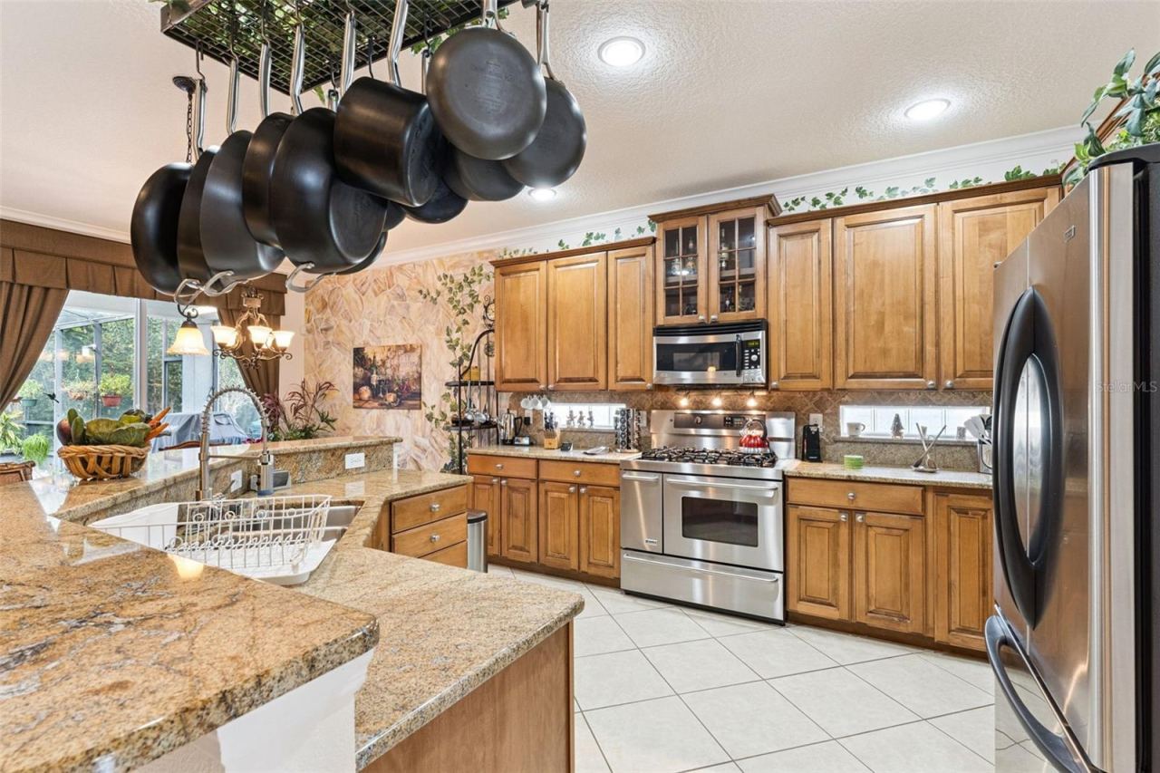 Photo 9 of 20: 13' x 13'6" Kitchen w/ granite countertops, 5-burner natural gas convection range & exterior wall glass block inserts