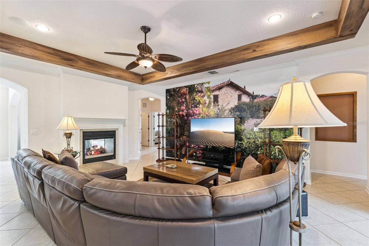 Photo 15 of 20: Family Room w/ a double sided natural gas fireplace, decorative accent wall & crown molding