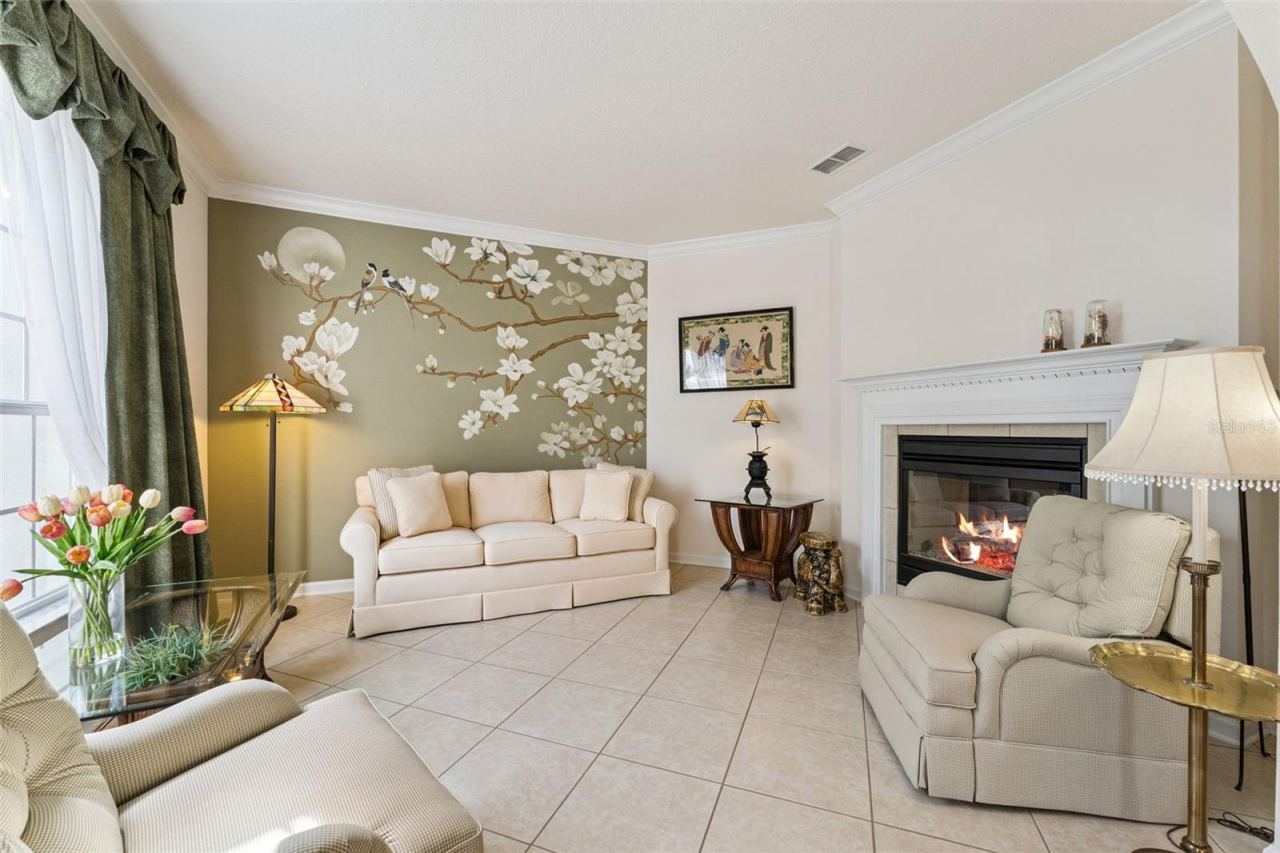 Photo 4 of 20: 12' x 14' Living Room w/ crown molding, accent wall & a double sided natural gas fireplace