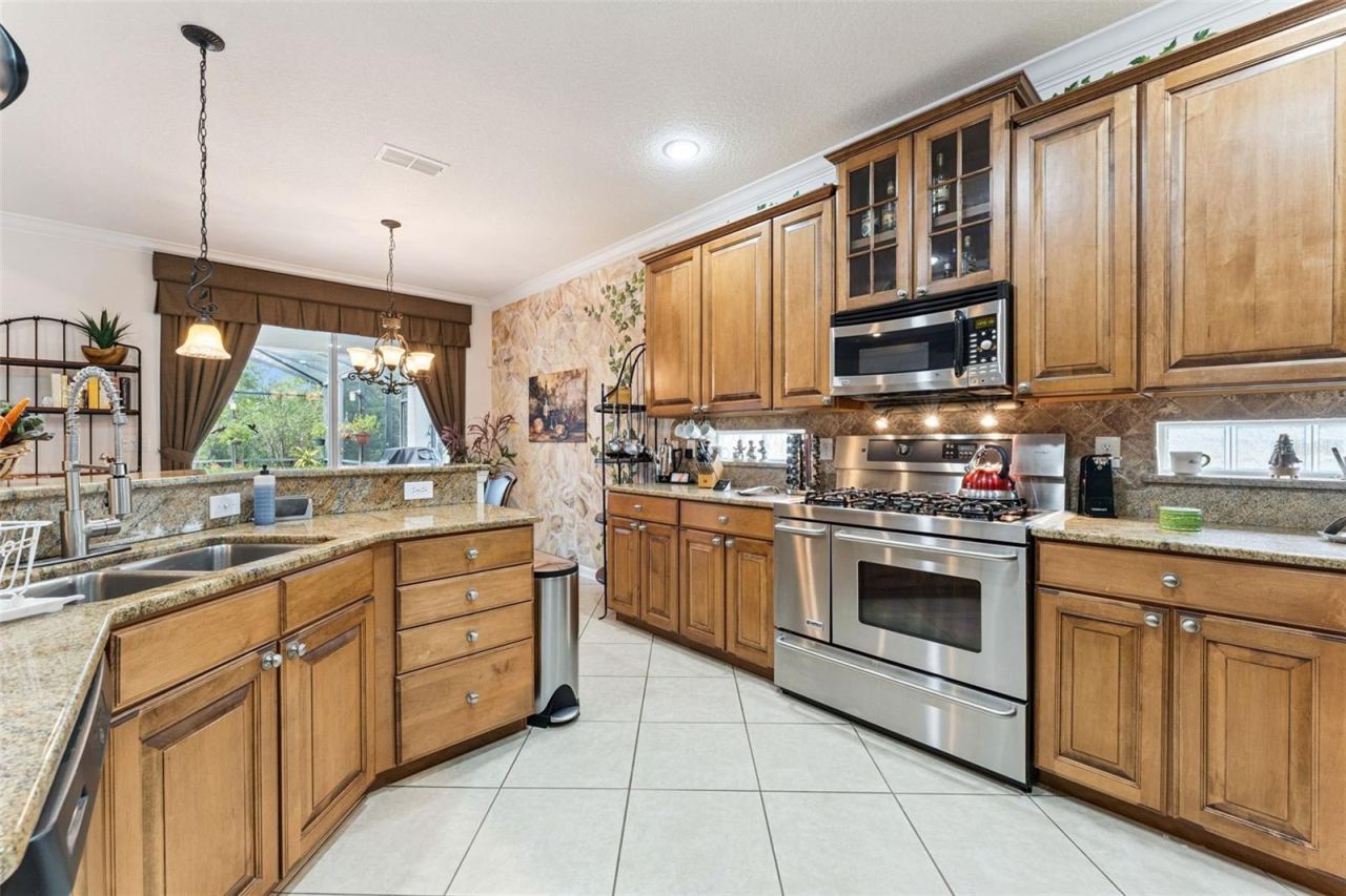 Photo 10 of 20: Kitchen w/ stainless steel appliances, tile backsplash & 42" Maple cabinets