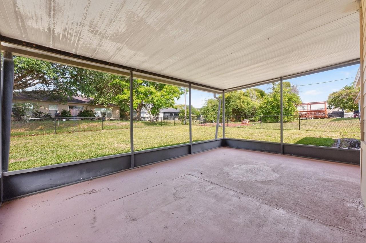 Photo 16 of 20: Step outside to the ENCLOSED SCREENED PATIO overlooking the SPACIOUS FENCED BACKYARD, offering the perfect place to relax, entertain, or enjoy outdoor living year-round.