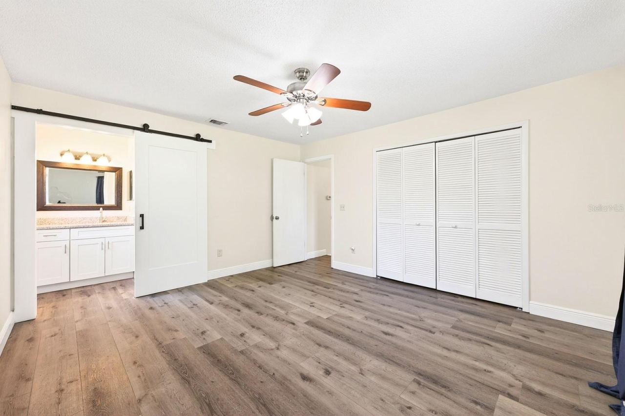 Photo 11 of 20: The Primary Suite offers privacy and comfort, complete with a large built-in closet and an en suite bath accented by a STYLISH BARN DOOR.