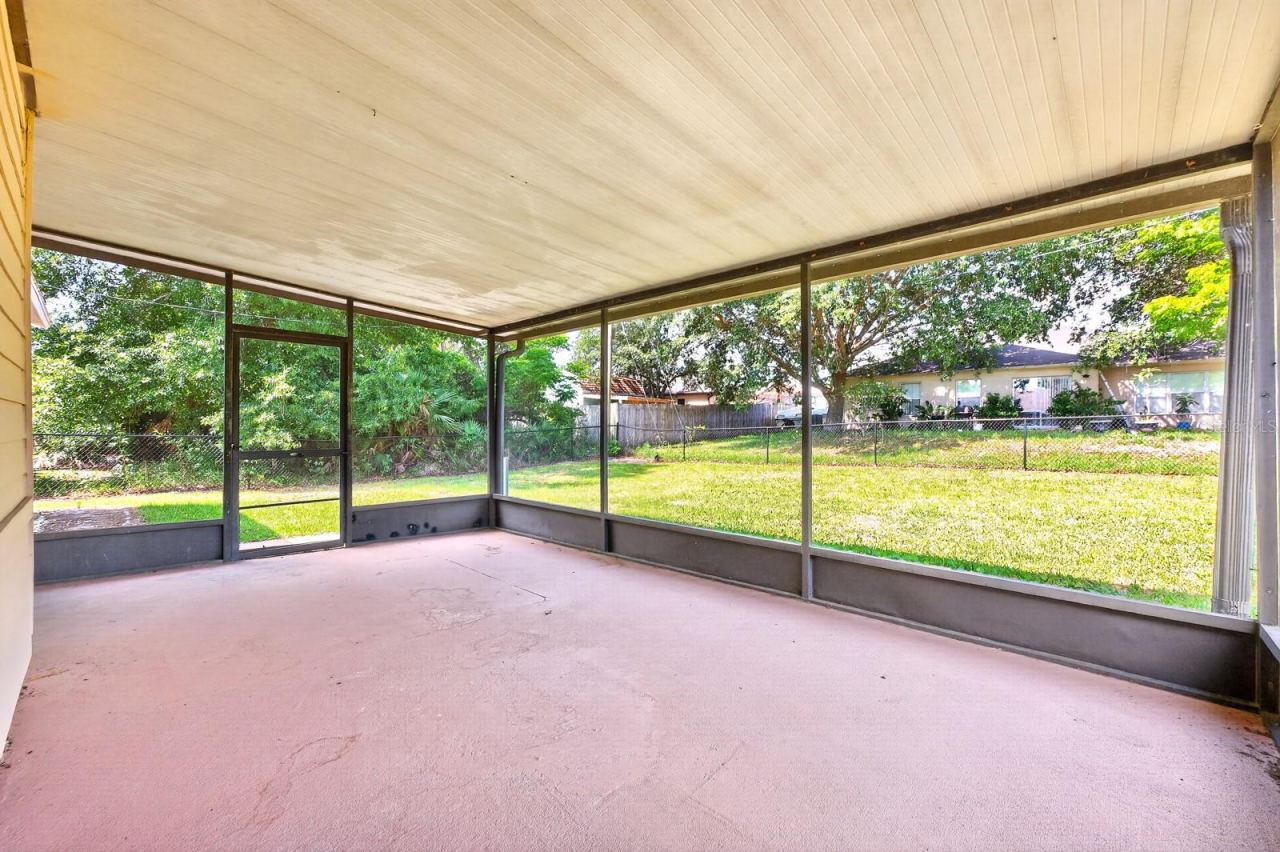 Photo 17 of 20: Step outside to the ENCLOSED SCREENED PATIO overlooking the SPACIOUS FENCED BACKYARD, offering the perfect place to relax, entertain, or enjoy outdoor living year-round.