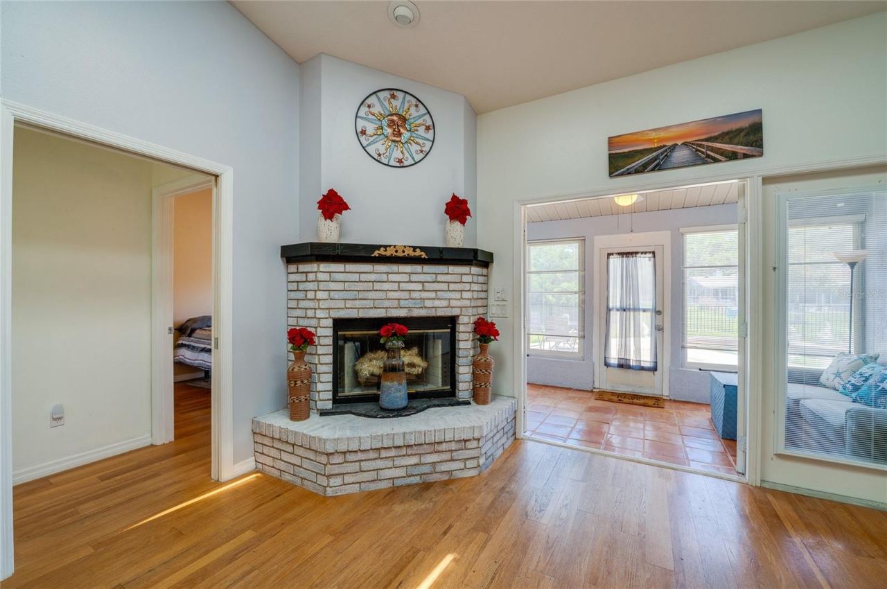 Photo 17 of 20: Wood-burning fireplace, French doors open to Florida room