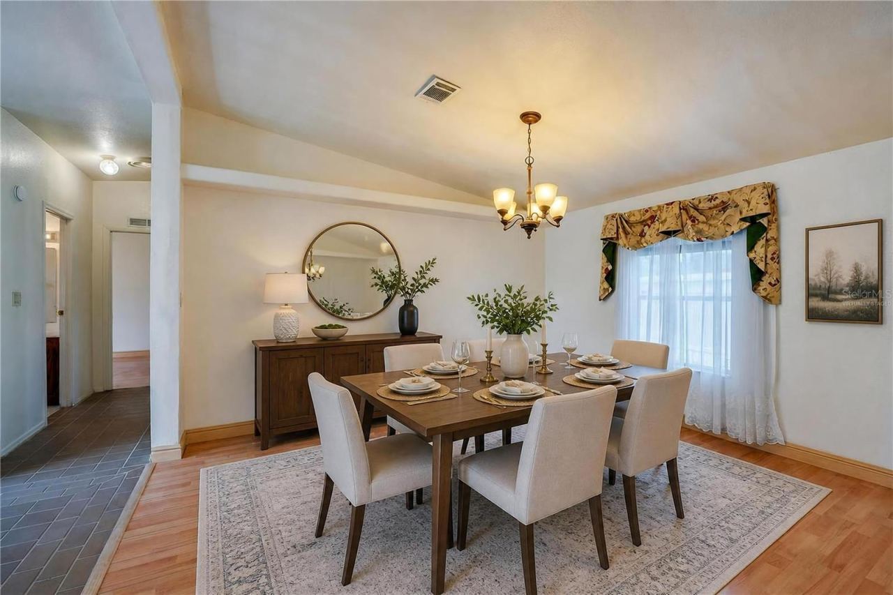 Photo 14 of 20: Virtually Staged...Defined dining space features a chandelier and a large window for natural light, with an open connection to the surrounding living areas.