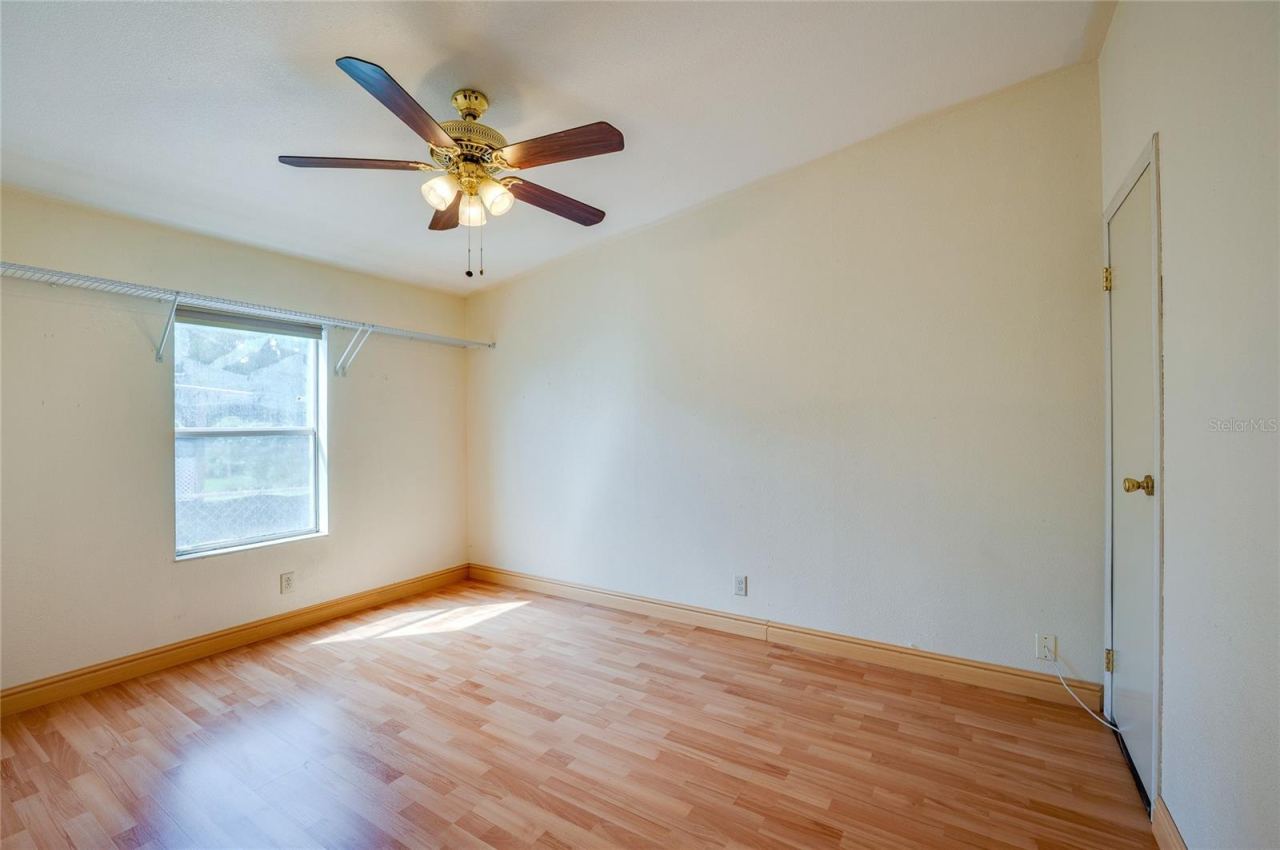 Photo 20 of 20: Bright bedroom features a ceiling fan, window for natural light, and ample open space for flexible furniture placement.