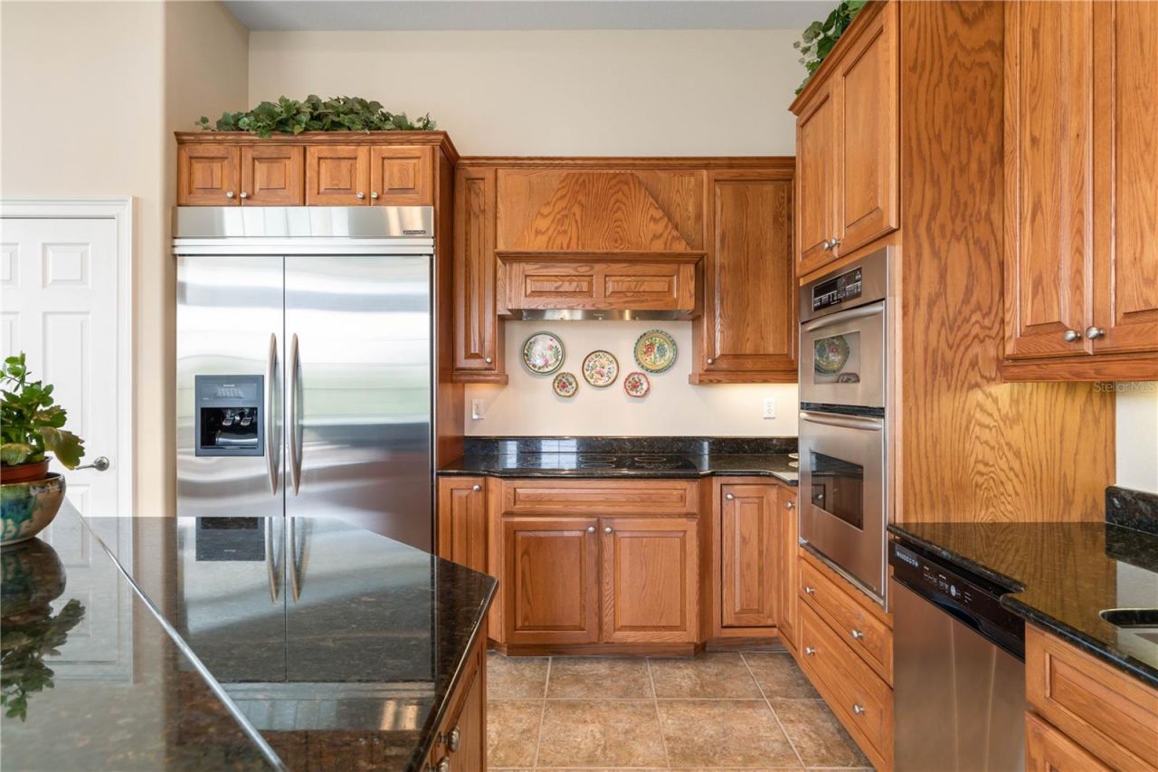 Photo 7 of 20: Designed to outlast trends, the kitchen combines warm, timeless finishes with granite countertops, a commercial-style refrigerator and double wall ovens for everyday function and effortless entertaining.