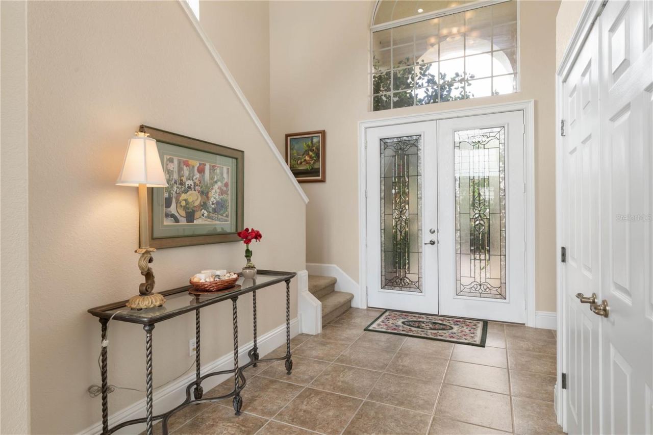 Photo 15 of 20: From the foyer, the home reveals its two-story design, with the staircase drawing the eye upward while the main living spaces continue ahead.