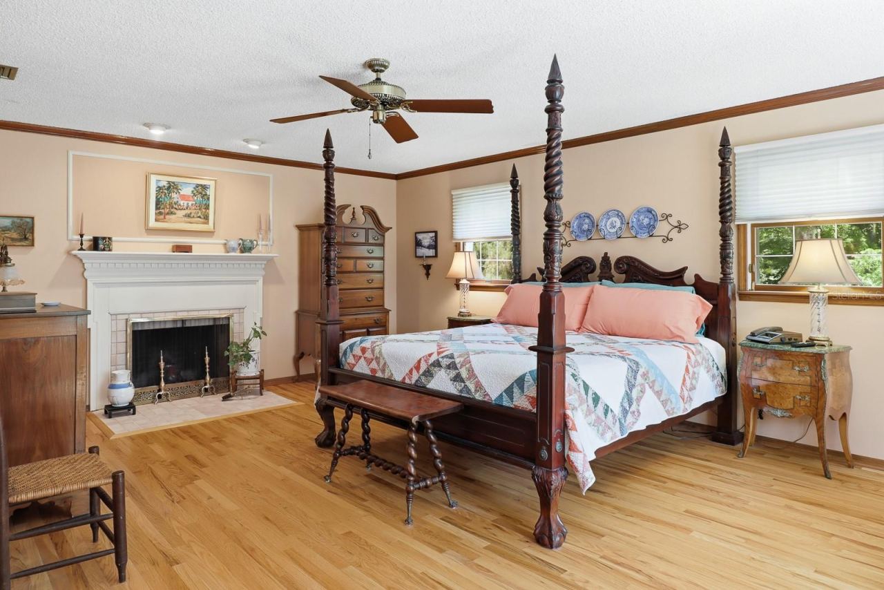 Photo 18 of 20: Primary bedroom with wood burning fireplace.