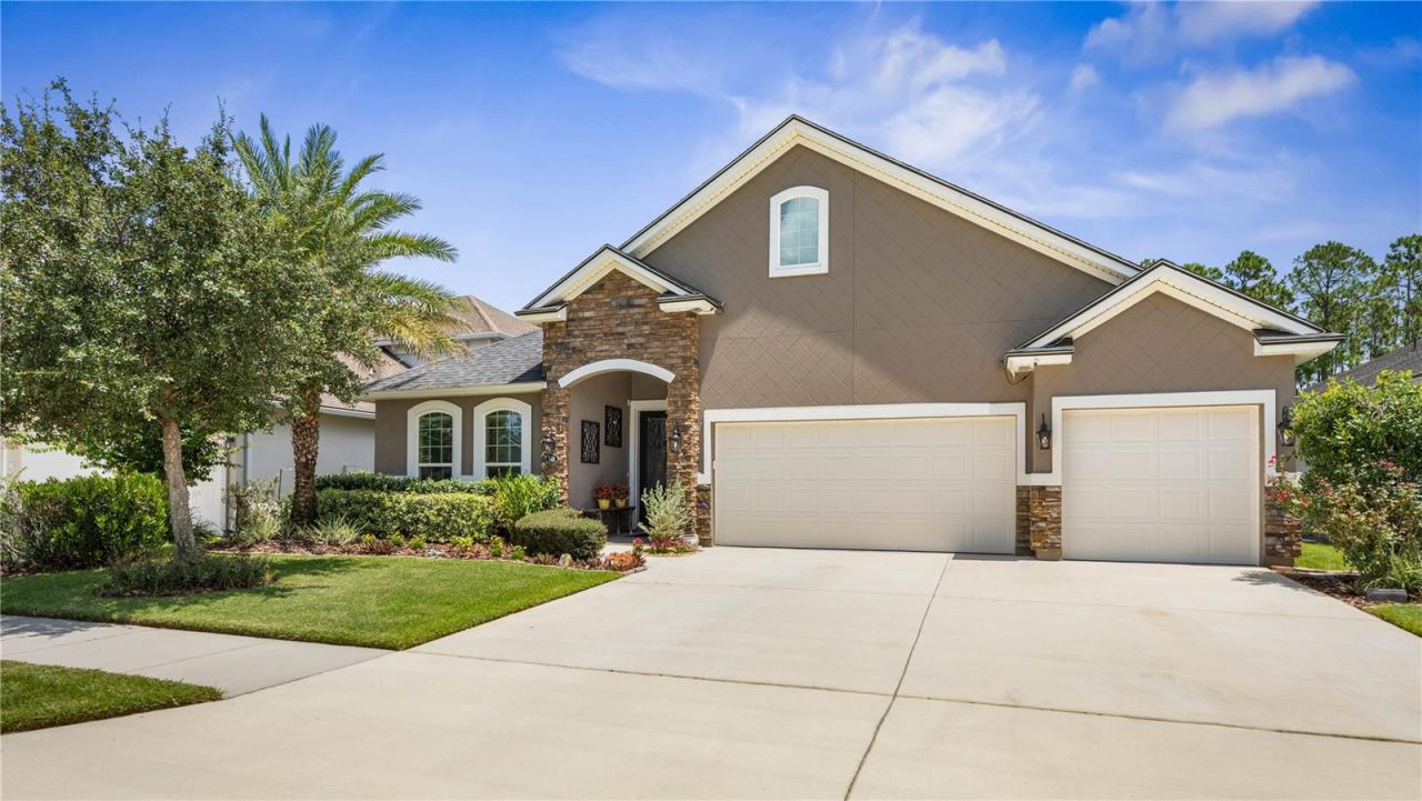 Photo 1 of 20: Picture yourself pulling up to this beautifully maintained home each day—lush landscaping, warm stone accents, and a welcoming tiled entry make coming home feel good from the very start.