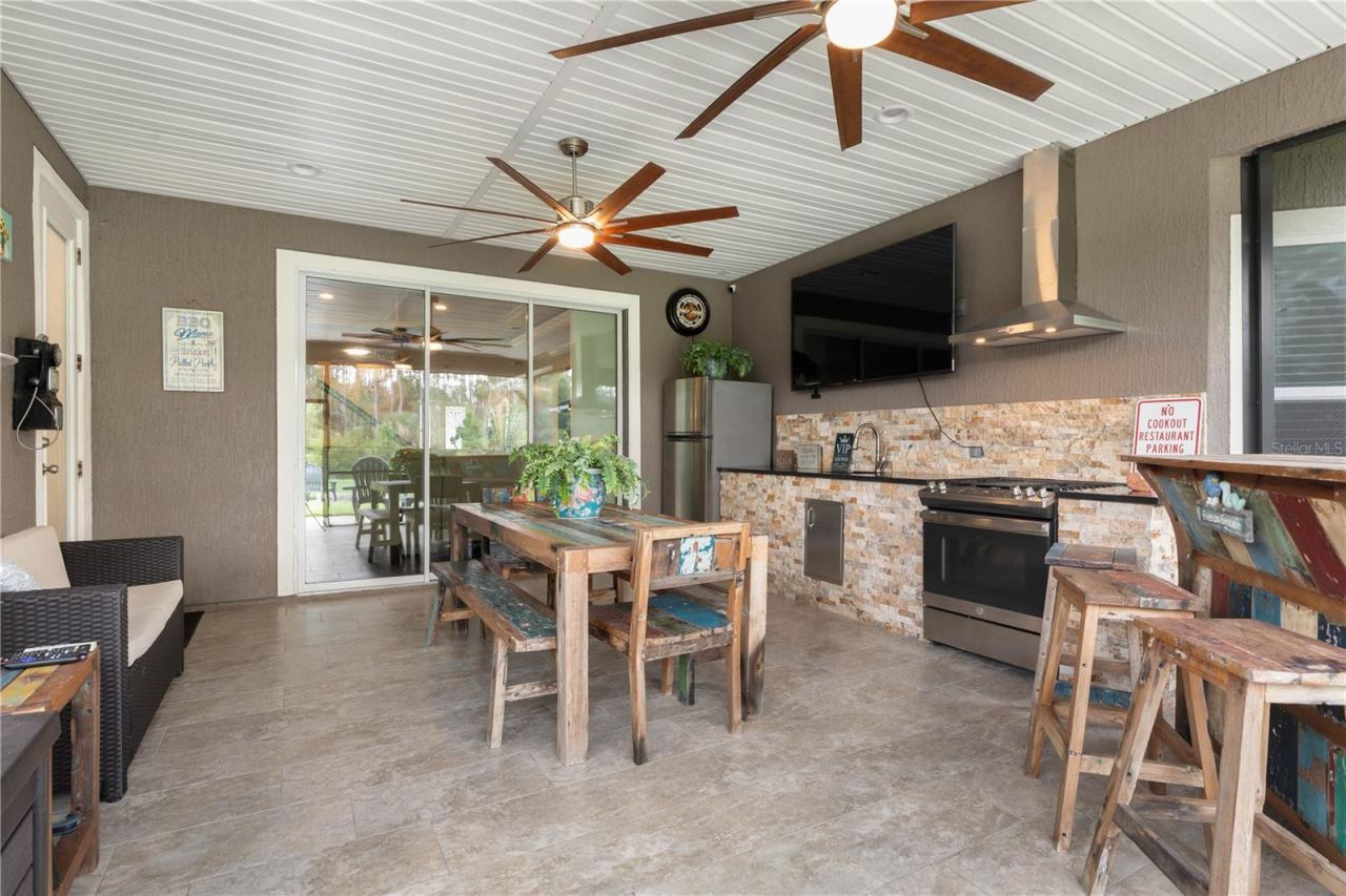 Photo 8 of 20: Outdoor living just got better—this covered lanai is ready for year-round fun with a gas stove and oven, outdoor kitchen, bar seating, and plenty of space to gather with family and friends.
