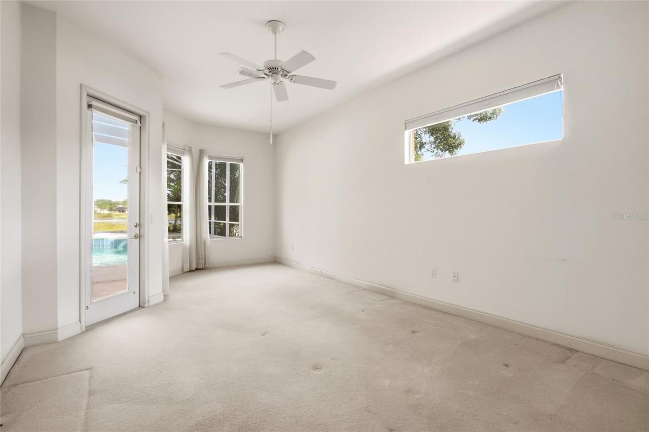 Photo 13 of 20: Primary suite in a three-way split bedroom plan, with direct access to the covered porch andscreened pool.