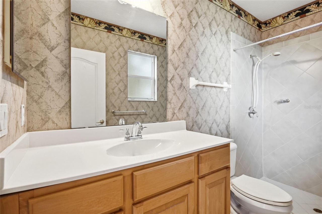 Photo 20 of 20: Full guest bathroom with a separate shower and outdoor access, conveniently serving as thepool bath.