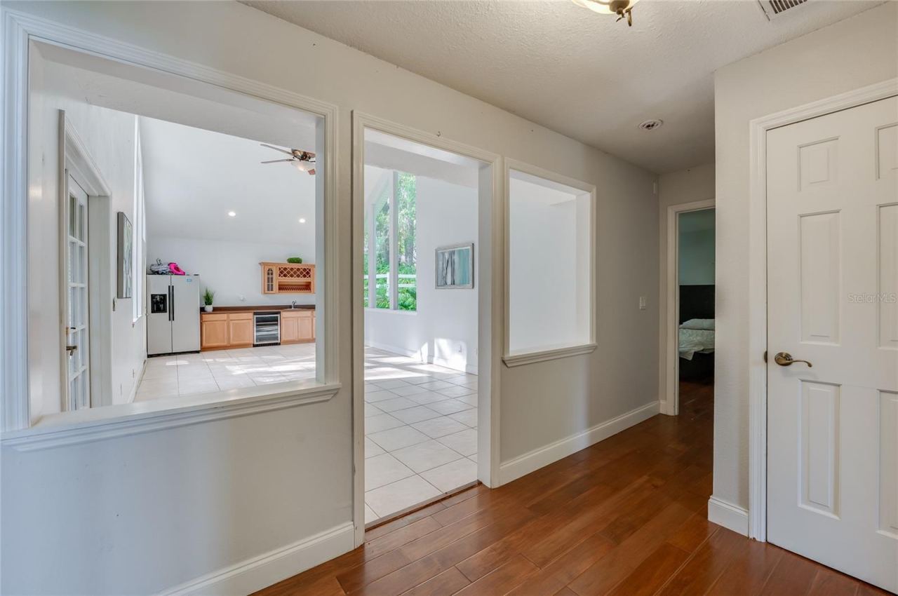 Photo 7 of 20: Entryway showcase featuring rich laminate flooring that opens into a bright, tiled interior flex space.