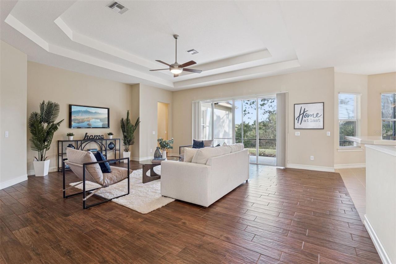 Photo 6 of 20: 22' x 21' Family Room w/ porcelain plank tile, double tray ceiling & a ceiling fan
