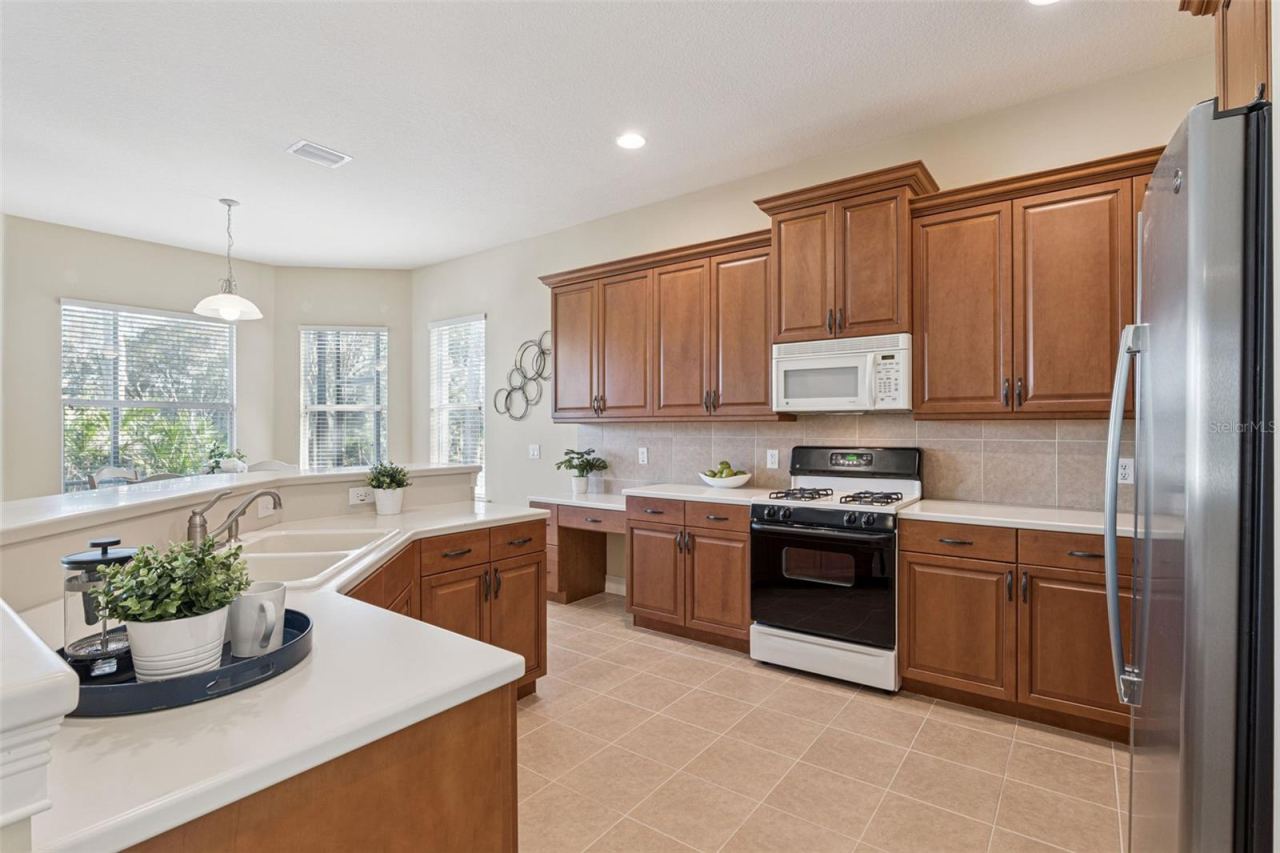 Photo 11 of 20: 13' x 14'6" Kitchen w/ 42" Maple cabinets, Corian countertops & tile backsplash