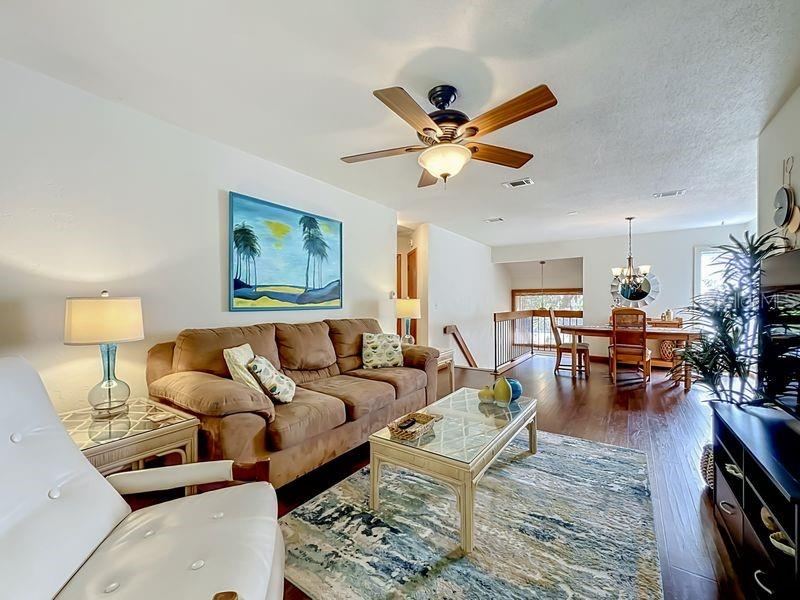 Photo 7 of 20: Living Room view to Dining Room-Bright and open with plenty of natural lighting. Engineered wood flooring and sliders to Florida Room