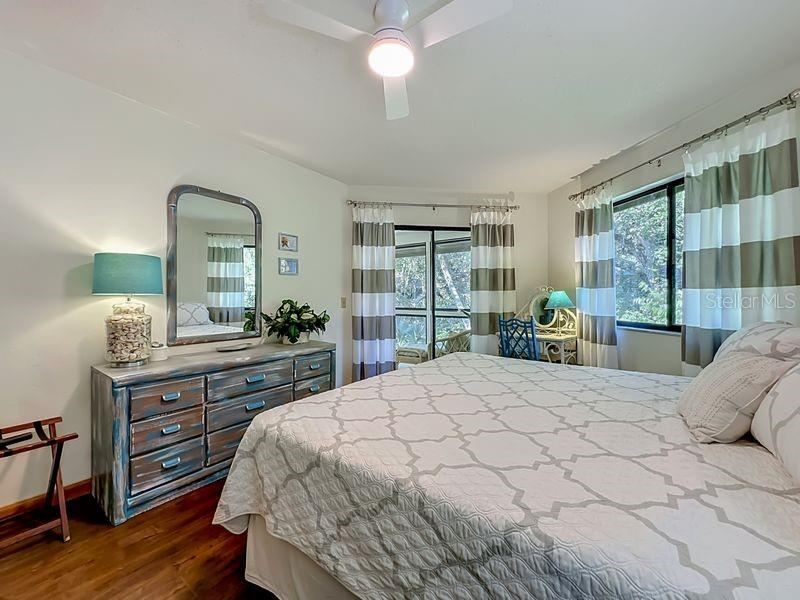 Photo 14 of 20: Primary Bedroom: Engineered Wood flooring - Large window and sliders to Florida Room