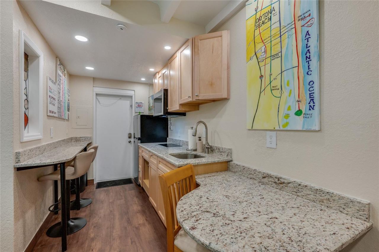 Photo 13 of 20: Compact and functional kitchen setup with ample counter space and essential appliances, perfect for preparing beachside snacks or full meals.