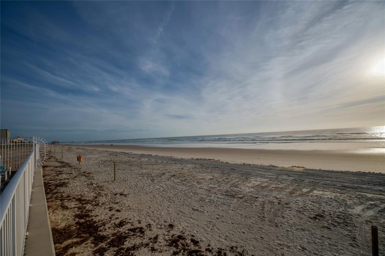 Photo 9 of 20: Pristine stretch of sandy beach just steps from the complex, offering a serene setting for long walks, sunbathing, or enjoying the rhythmic sounds of the waves.