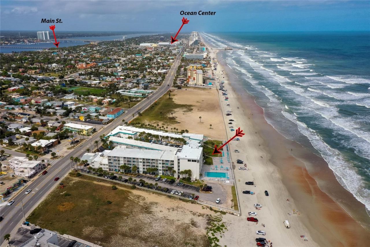 Photo 3 of 20: Aerial shot of the complex's recreational area, highlighting the large community pool, sun deck, and private beach access gate for residents and guests.