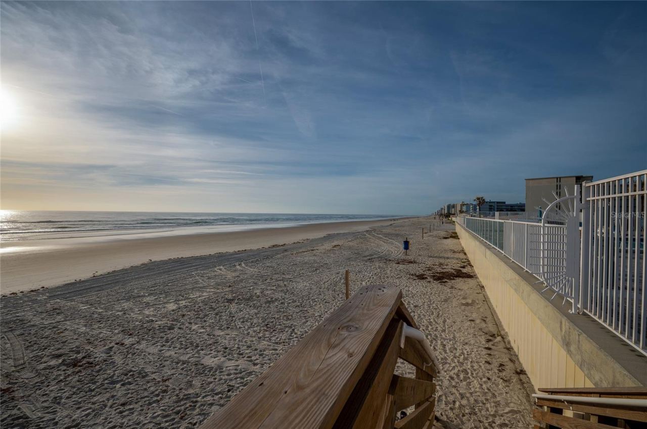 Photo 10 of 20: Panoramic view of the shoreline where the golden sands meet the blue waters.