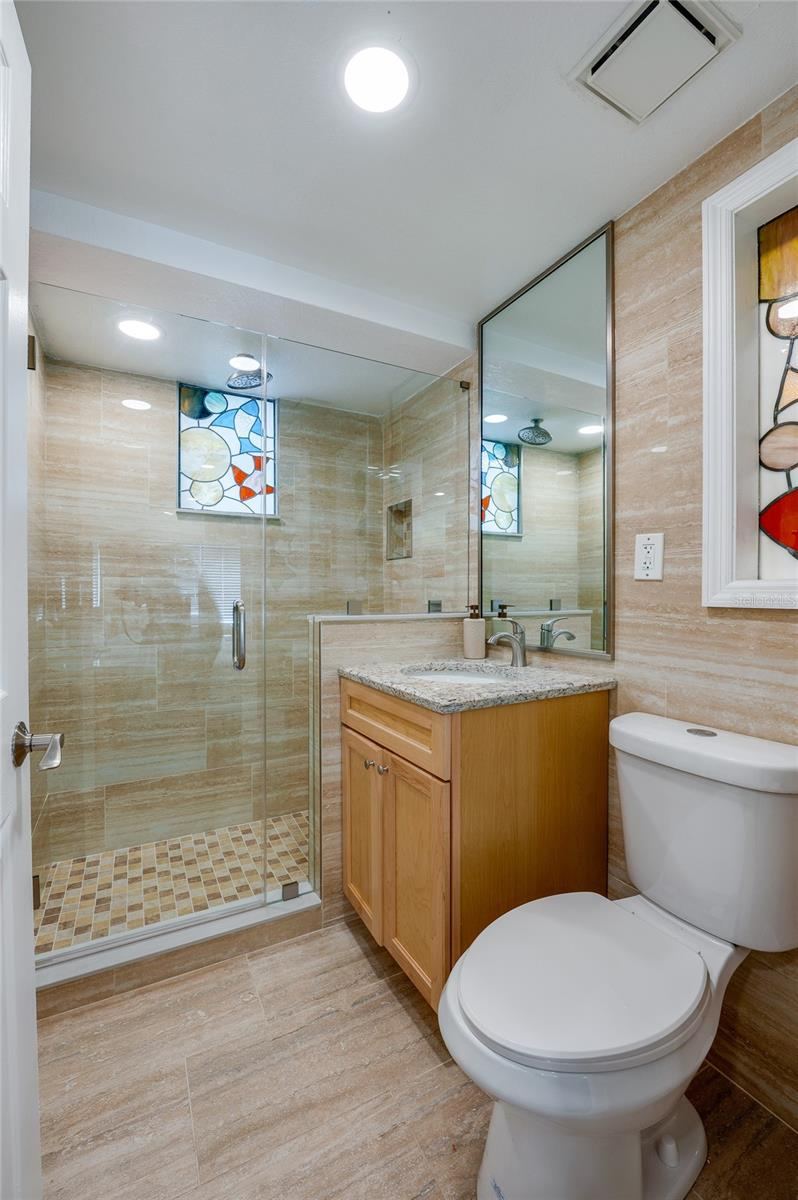Photo 20 of 20: Clean and modern bathroom featuring a shower, large vanity mirror, and updated fixtures that maintain the property’s refreshed aesthetic.