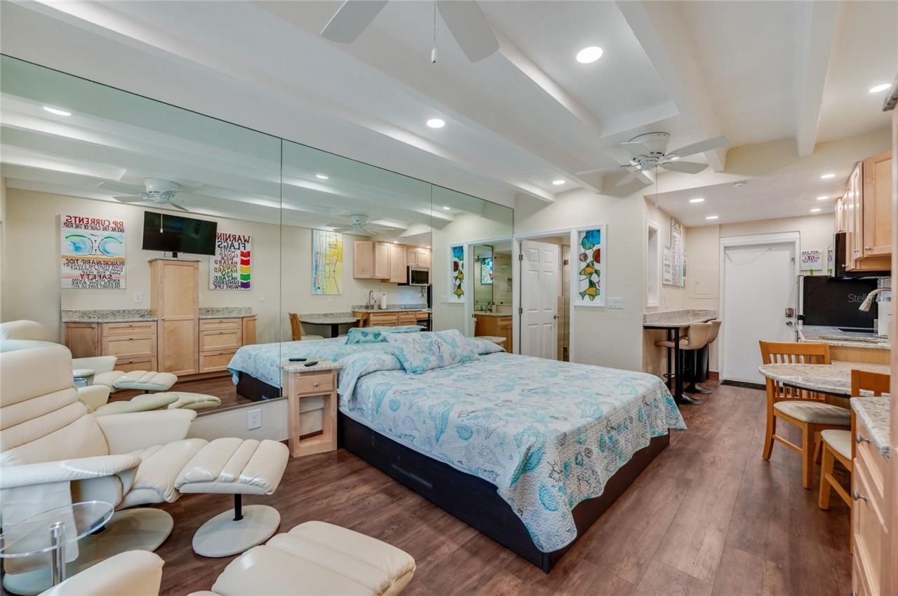 Photo 16 of 20: Spacious studio layout with neutral flooring throughout, designed to maximize both seating and sleeping areas for a comfortable coastal retreat.