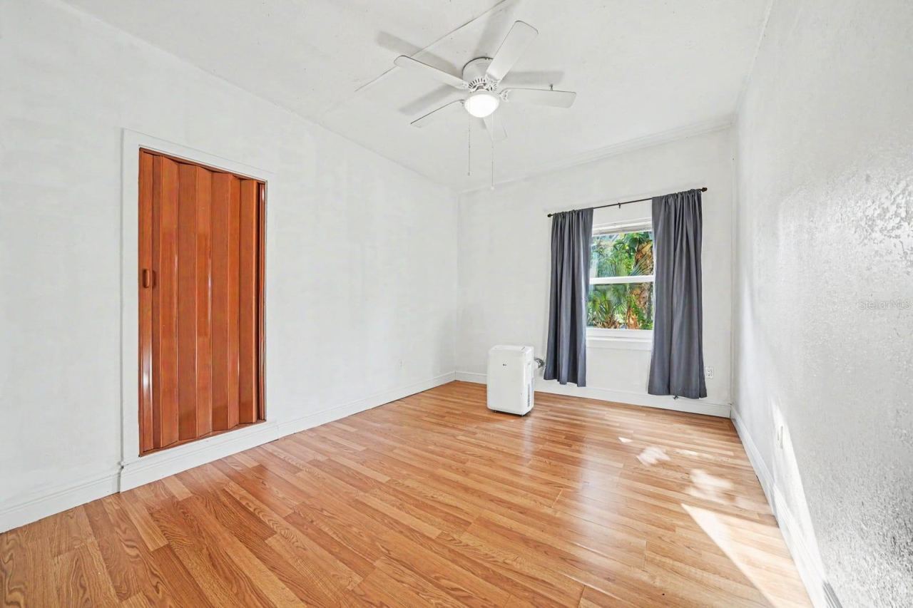 Photo 16 of 20: Bedroom with Hardwood Floors, Ceiling Fan & Window with Landscape Views