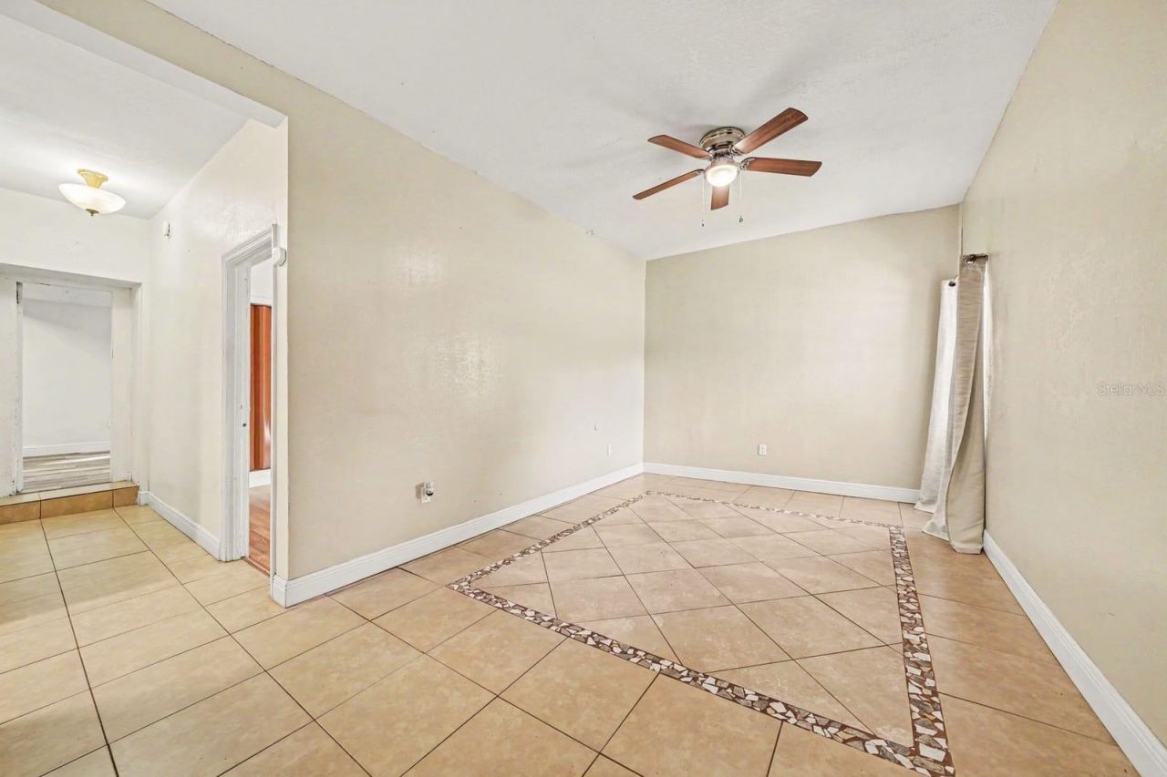 Photo 15 of 20: Spacious Living Room with Ceiling Fan, Tile Flooring & Multiple Entry Points