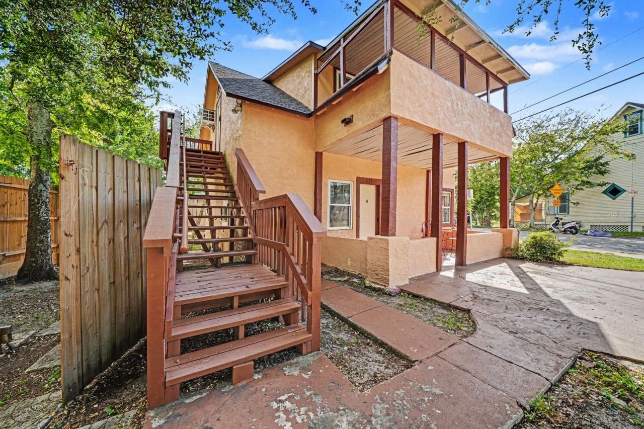 Photo 3 of 20: Elevated Home With Red Wooden Stairs & Ground-Level Access