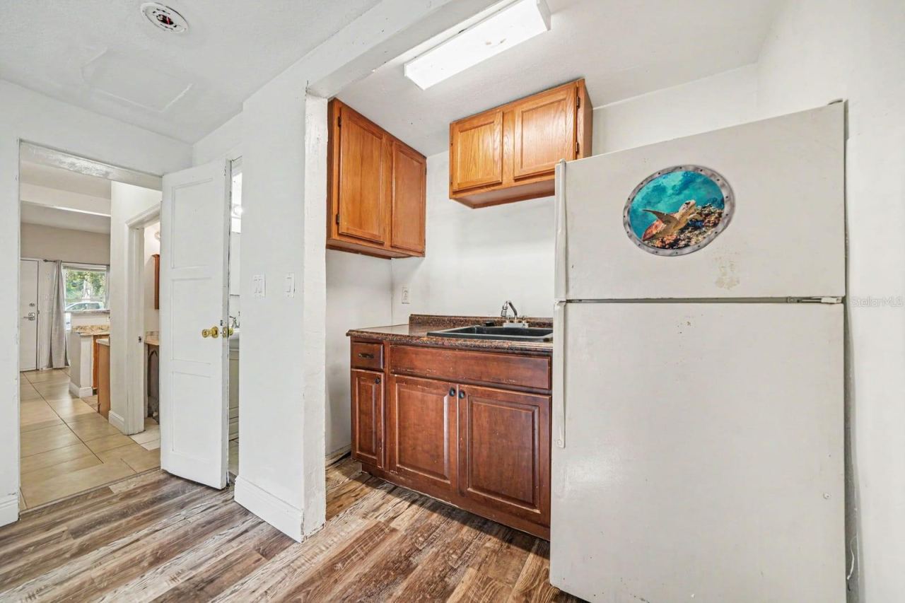 Photo 12 of 20: Compact Kitchen with Wood Cabinets, Sink & Access to Main Living Area
