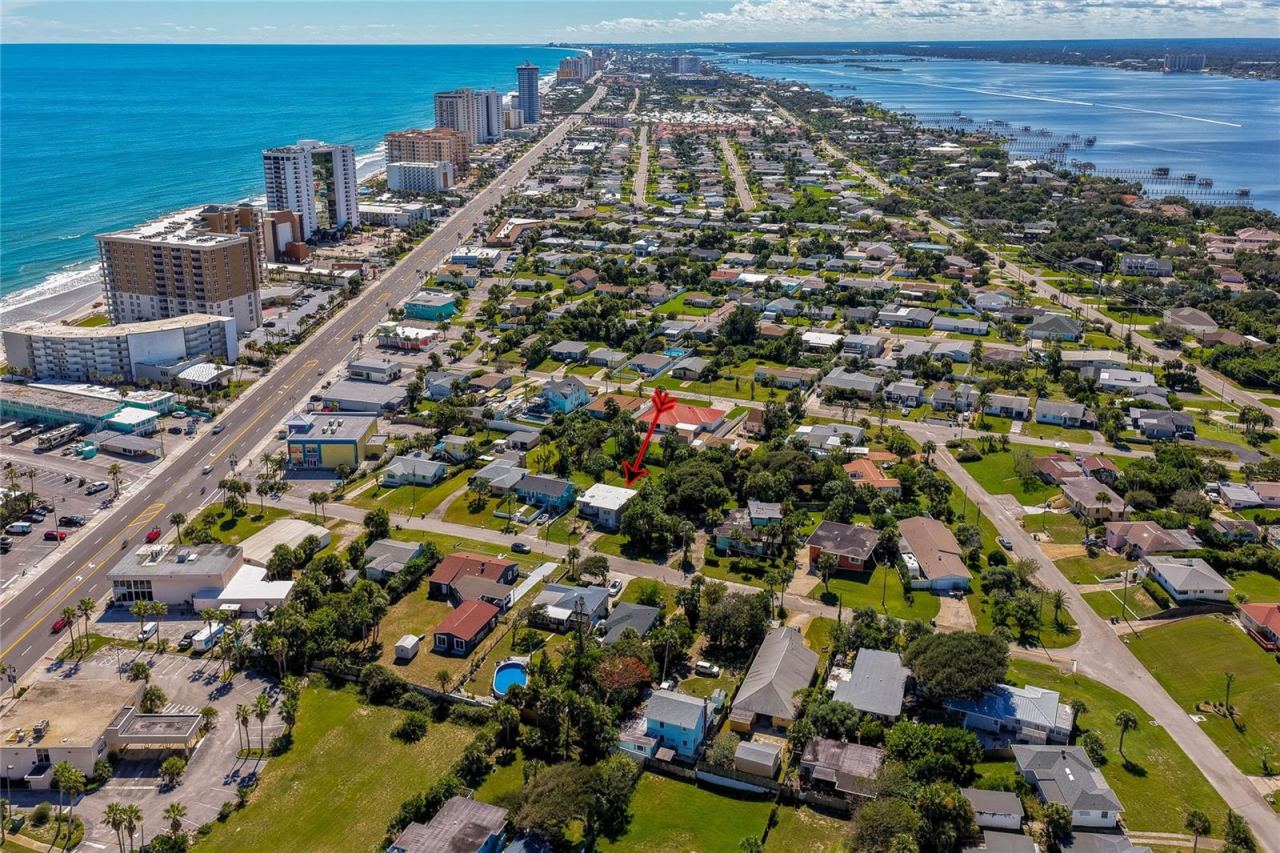 Photo 2 of 20: Panoramic aerial view capturing the property set between the ocean shoreline and the intracoastal waterway. The elevated perspective highlights the surrounding residential layout and scenic coastal landscape.