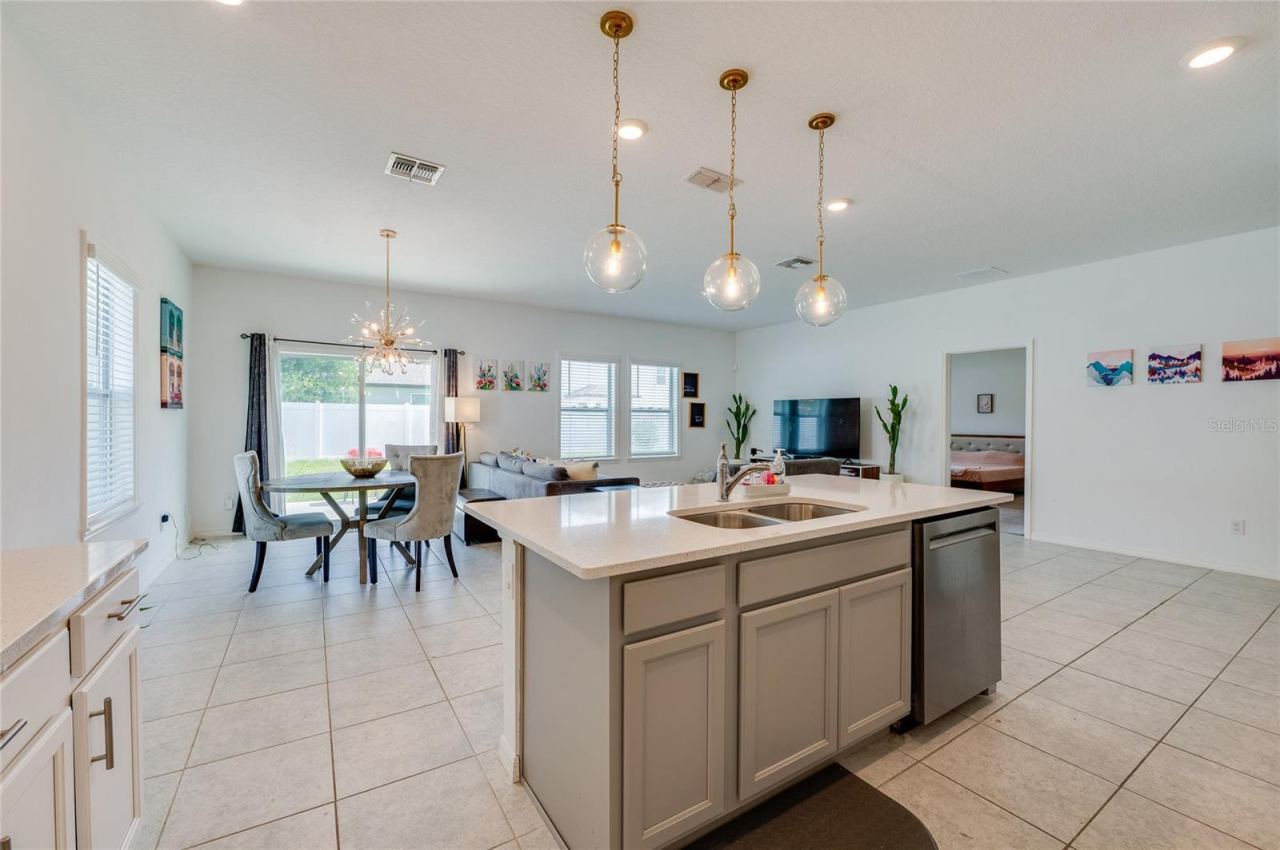 Photo 11 of 20: A wide perspective from behind the kitchen island looking across the entire main living area, showcasing the expansive, airy feel of the home's open layout.
