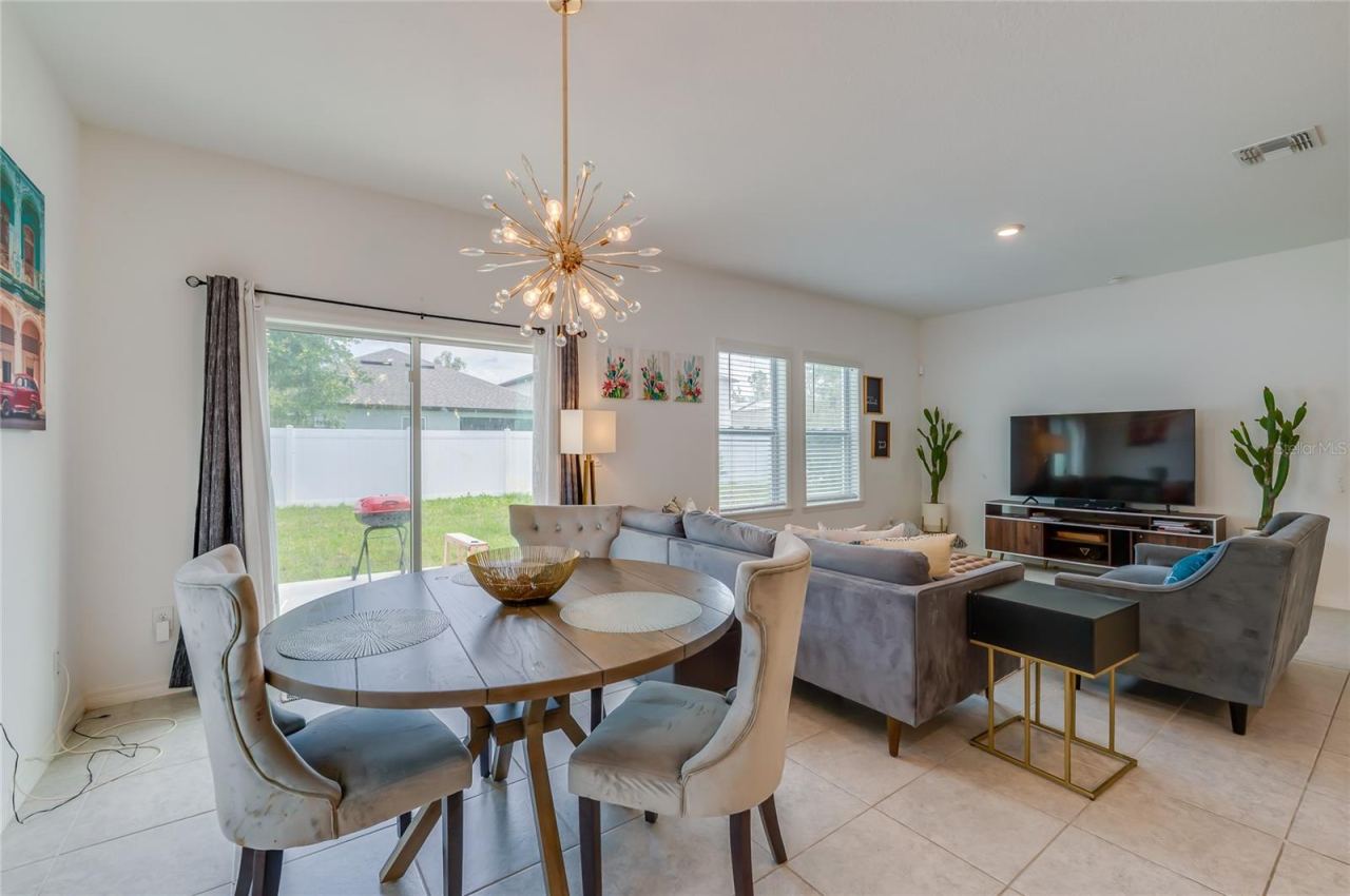 Photo 16 of 20: Dedicated dining nook situated next to a sliding glass door that opens directly to the backyard. A striking starburst chandelier serves as a focal point for the space.